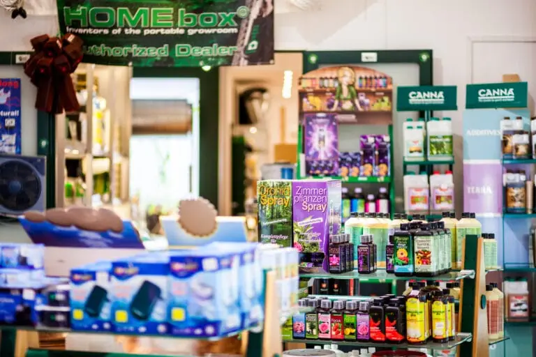 Theke im GrowCologne Growshop, dahinter Regale mit Pflanzensprays und Düngerflaschen